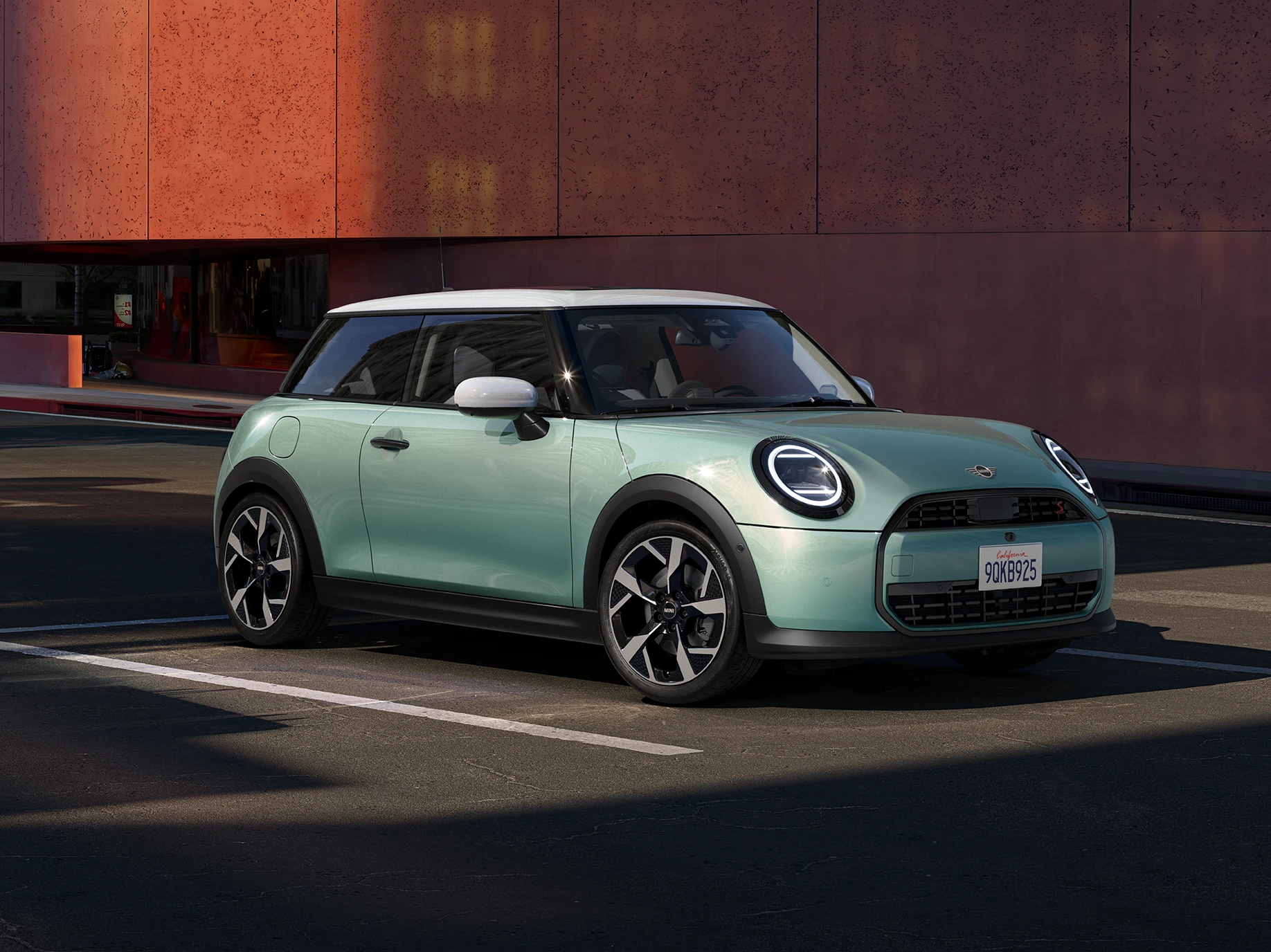 Страничен преден  поглед на MINI Cooper во зелена боја Ocean Wave Green и бел кров White Roof.