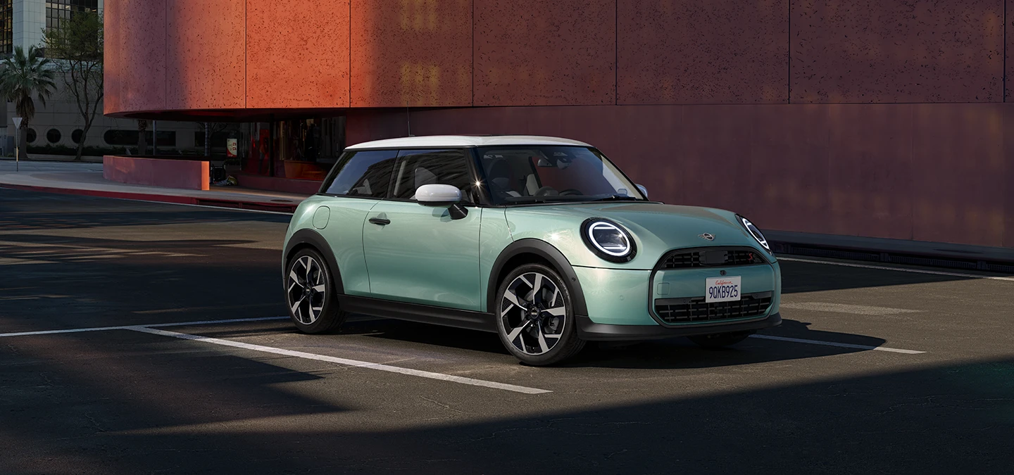 Страничен преден  поглед на MINI Cooper во зелена боја Ocean Wave Green и бел кров White Roof.