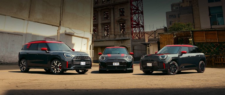 MINI Countryman John Cooper Works in Nanuq White Metallic driving through an urban intersection.