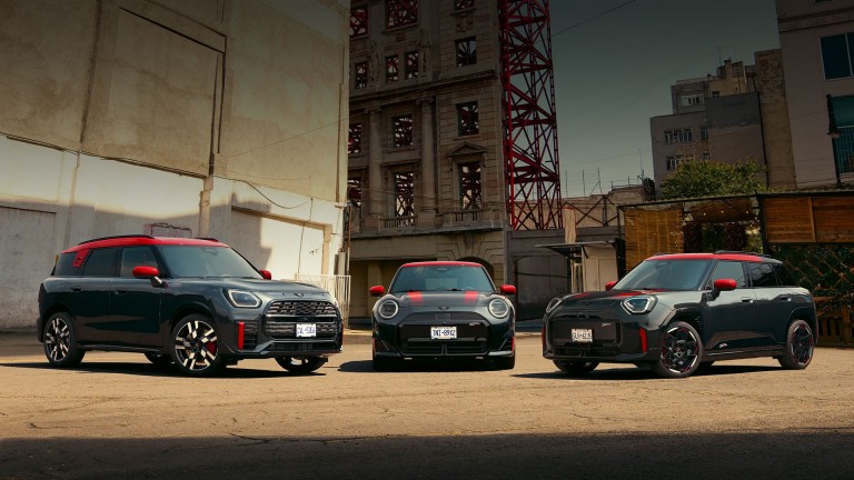 MINI Countryman John Cooper Works in Nanuq White Metallic driving through an urban intersection.
